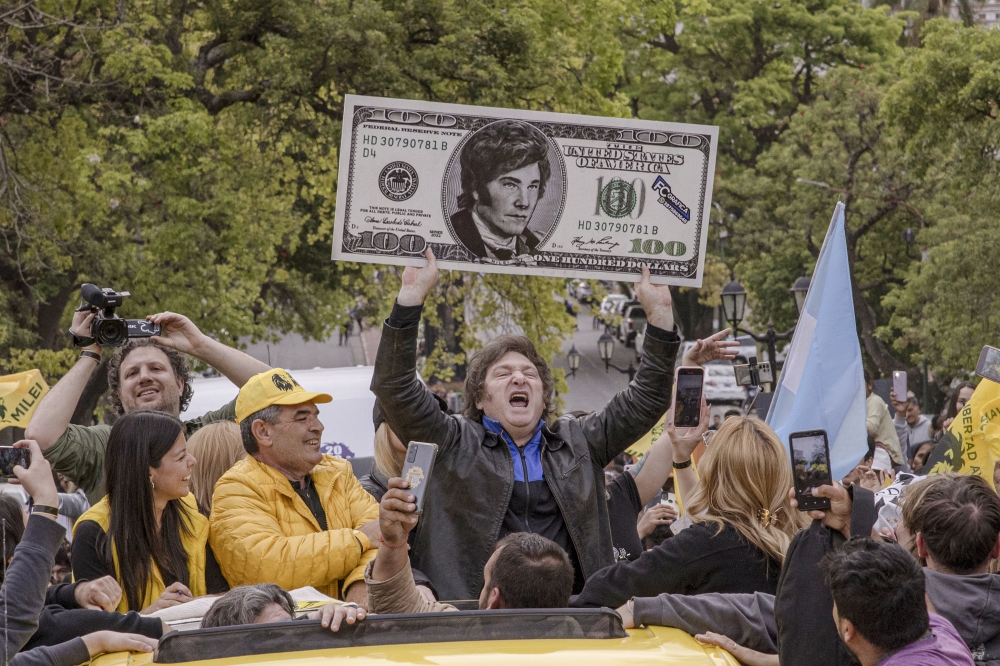 Javier Milei, a presidential candidate for the Libertad Avanza party, with a 100-dollar bill featuring his face during an election event in Salta, Argentina on Oct 12, 2023. (Sarah Pabst/The New York Times)