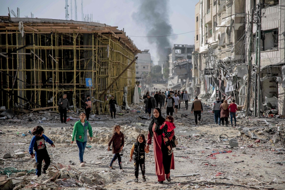 Palestinians walk amid the rubble of destroyed buildings in Gaza City on the northern Gaza strip. — AFP 