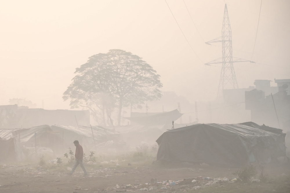 A man walks past litter amid dense smog in Amritsar