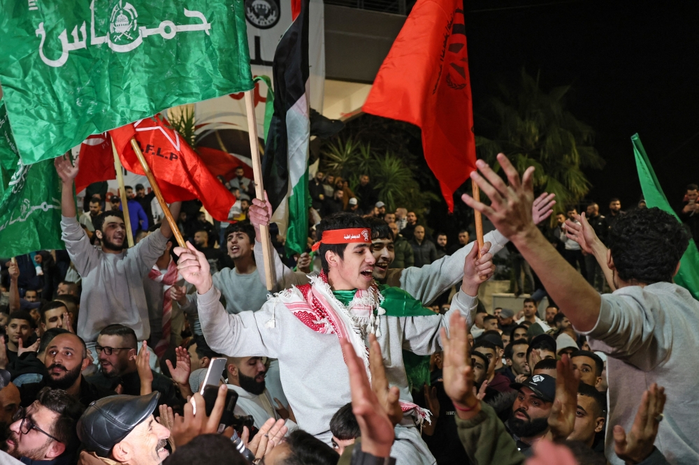 Palestinians cheer among supporters after being released from Israeli jails, in Ramallah in the occupied West Bank. — AFP 