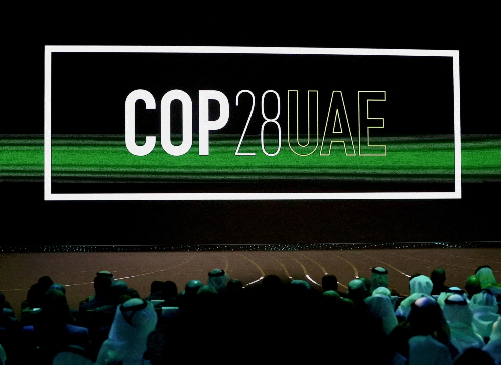 'Cop28 UAE' logo is displayed on the screen during the opening ceremony of Abu Dhabi Sustainability Week (ADSW) under the theme of 'United on Climate Action Toward COP28', in Abu Dhabi, UAE, January 16, 2023. REUTERS