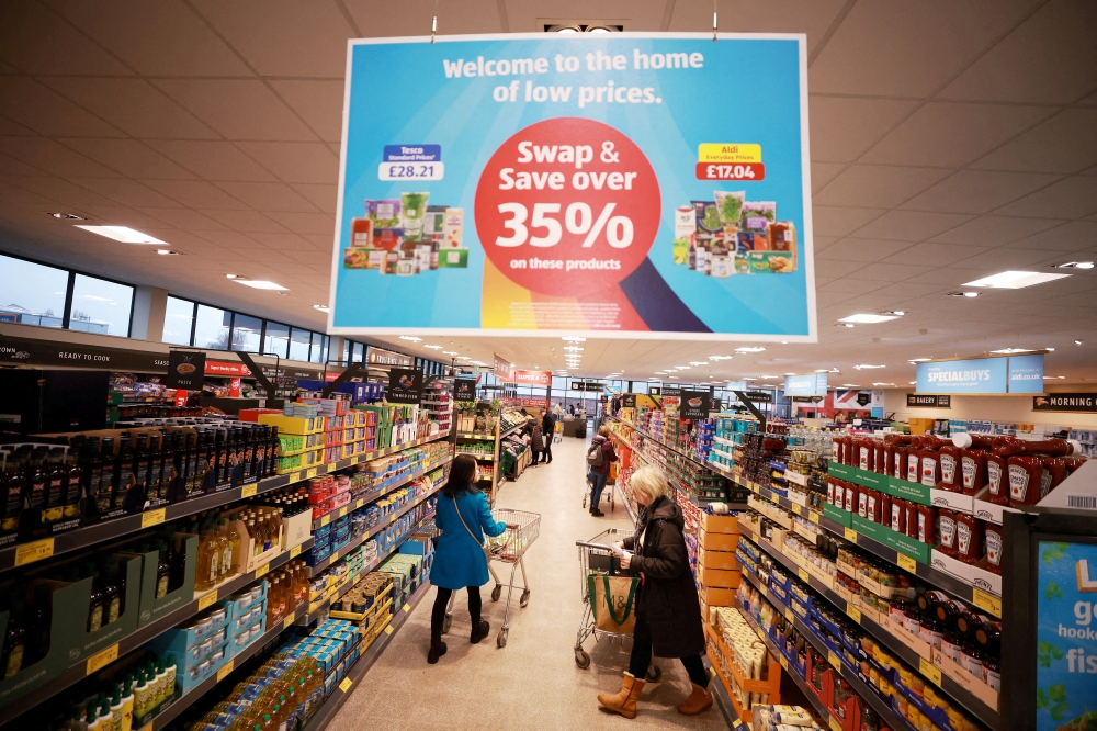 Shoppers push trolleys along an aisle inside an ALDI supermarket near Altrincham_Reuters