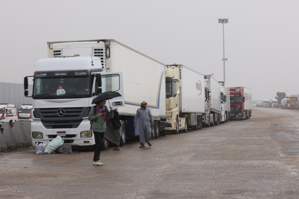 Trucks transporting humanitarian aid wait at the Rafah border crossing between Egypt and the Gaza Strip. — Reuters 