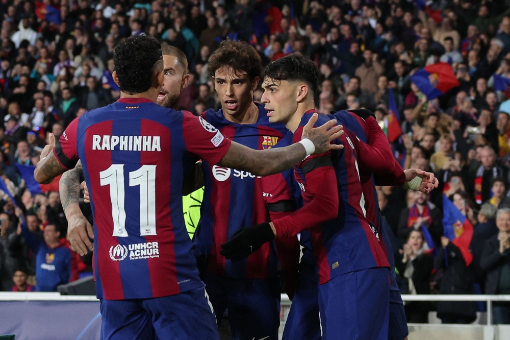 TOPSHOT - Barcelona's Portuguese forward #14 Joao Felix celebrates with teammates after scoring his team's second goal during the UEFA Champions League first round group H football match between FC Barcelona and FC Porto at the Estadi Olimpic Lluis Companys in Barcelona on November 28, 2023. (Photo by LLUIS GENE / AFP)

