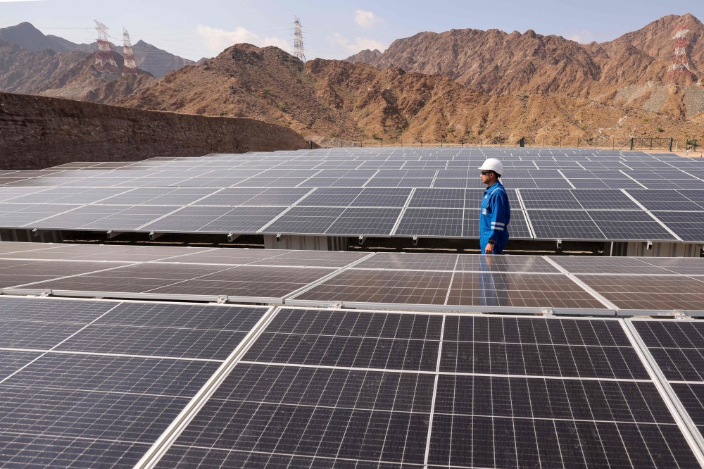 An engineer walks past solar panels at the ADNOC Facility in Fujairah. — AFP 