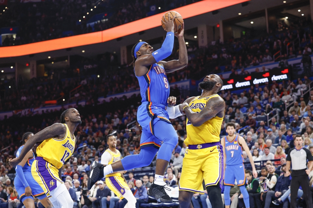 Nov 30, 2023; Oklahoma City, Oklahoma, USA; Oklahoma City Thunder guard Luguentz Dort (5) shoots over Los Angeles Lakers forward LeBron James (23) during the second half at Paycom Center. Mandatory Credit: Alonzo Adams-USA TODAY Sports
