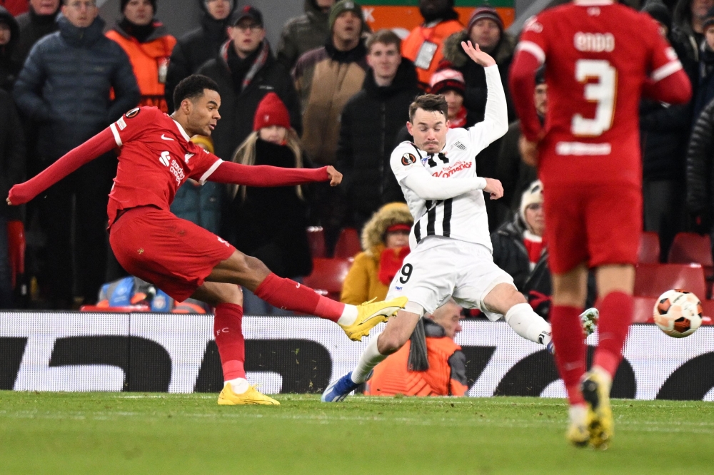 Liverpool's Dutch striker #18 Cody Gakpo (L) shoots to score their fourth goal during the UEFA Europa League group E football match between Liverpool and Linzer ASK at Anfield in Liverpool, north west England on November 30, 2023. Liverpool won the game 4-0. (Photo by Oli SCARFF / AFP)

