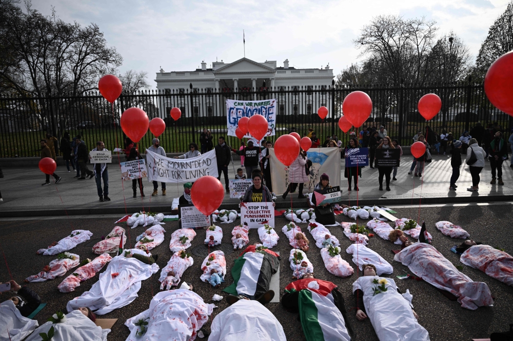Activists lay on the ground in front of the White House during a rally in support of Palestinians in Washington, DC
