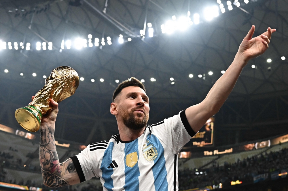 Argentina's captain #10 Lionel Messi poses with the FIFA World Cup Trophy 
