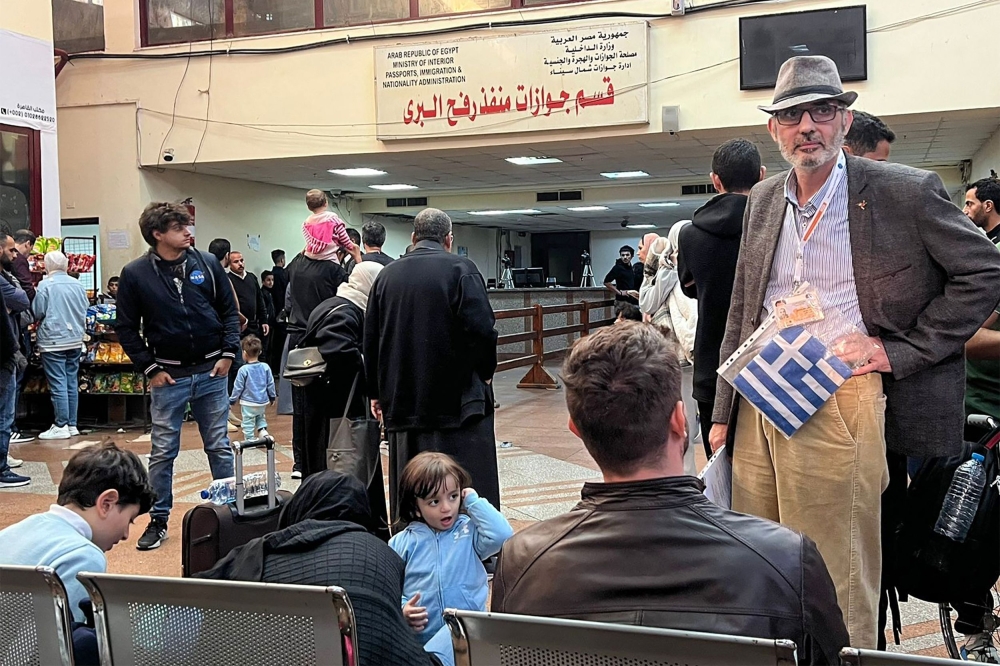 People fleeing from the Gaza Strip wait in the Egyptian part of the Rafah border crossing