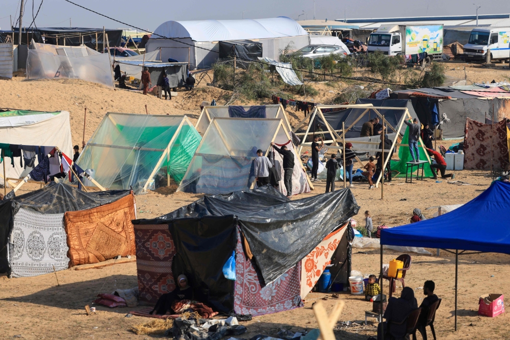 Displaced Palestinians who fled from Khan Yunis, build shelters in Rafah in the southern Gaza Strip. — AFP 