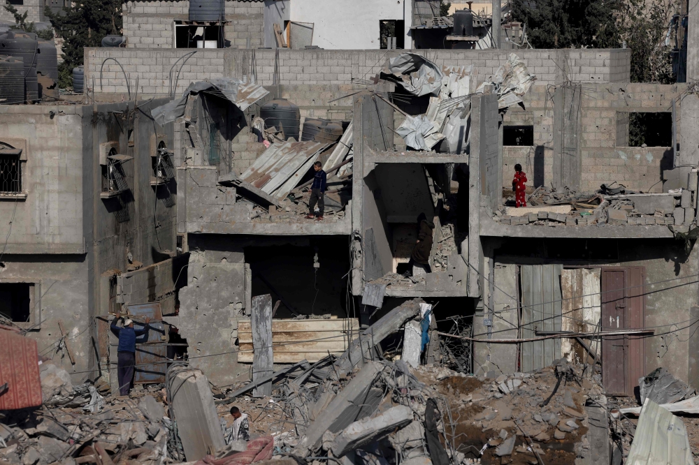 Palestinians inspect the damage in a residential area in Rafah in the southern Gaza Strip, following Israeli air strikes. — AFP