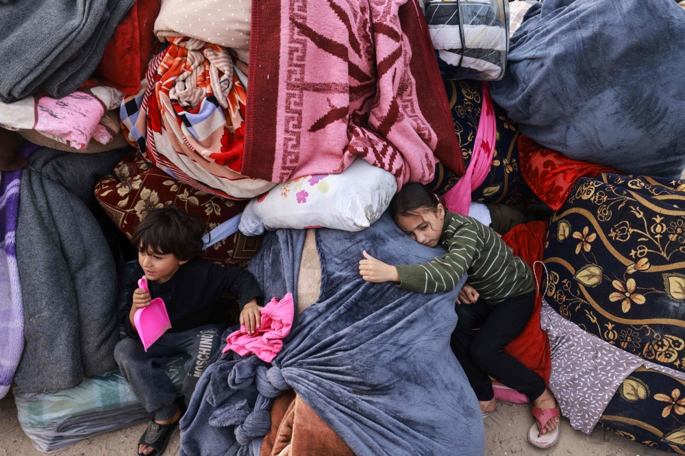 Children rest on blankets as displaced Palestinians fleeing central and southern Gaza set up tents in the new Tall el-Sultan camp west of Rafah in the southern Gaza Strip. — AFP 