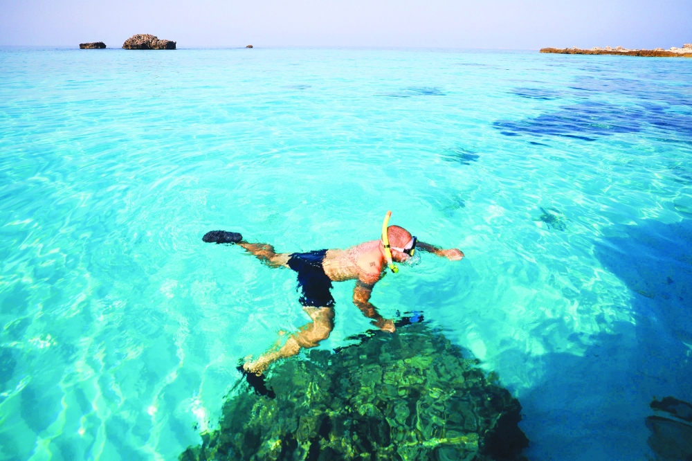 A volunteer takes part in a campaign to remove fishing nets from coral reefs at Daymaniyat Islands. — AFP