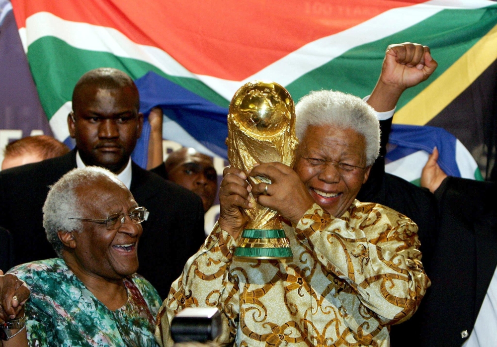 South African former President Nelson Mandela holds the Jules Rimet World Cup beside Archbishop Desmond Tutu, on May 15, 2004, at the FIFA headquarters in Zurich.