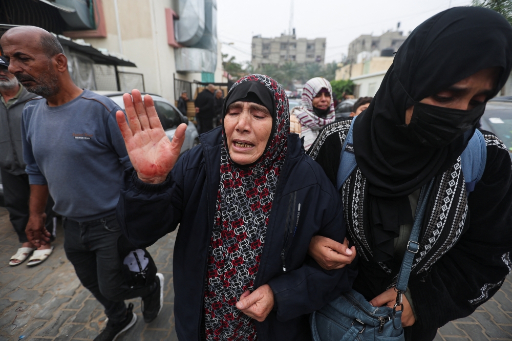 A Palestinian woman reacts, as the bodies of Palestinians who were killed during Israeli strikes on Ma'an school east of Khan Younis are laid out at Nasser hospital, amid the ongoing conflict between Israel and Palestinian Islamist group Hamas, in Khan Younis in the southern Gaza Strip, December 5, 2023. REUTERS/Ibraheem Abu Mustafa
