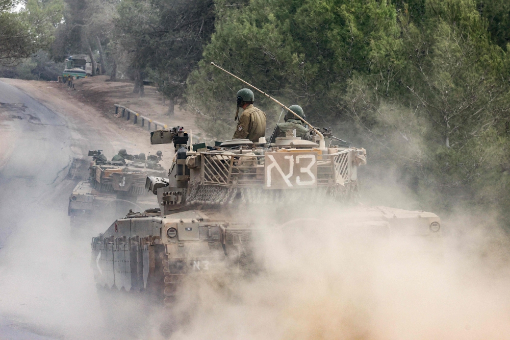TOPSHOT - Israeli military tanks roll near the border with the Gaza Strip on December 5, 2023, amid continuing battles between Israel and the militant group Hamas. Israel pressed on with its expanded ground operation against Hamas in the Gaza Strip, following the expiry of a seven-day truce on Friday, after which fighting resumed. Hamas militants from Gaza launched an unprecedented attack on southern Israel on October 7, killing about 1,200 people, mostly civilians, and taking around 240 hostages, according to Israeli officials.
