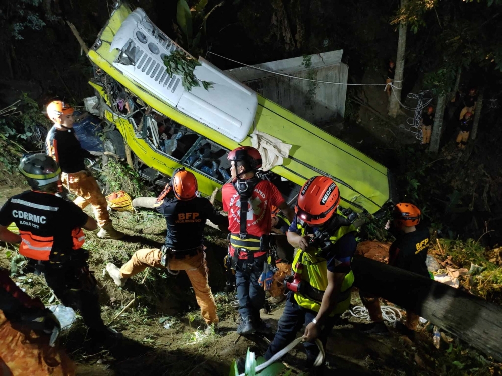 Rescuers conduct a retrieval operation after a bus carrying dozens of people lost its brakes and fell off a cliff in the central province of Antique, Philippines,