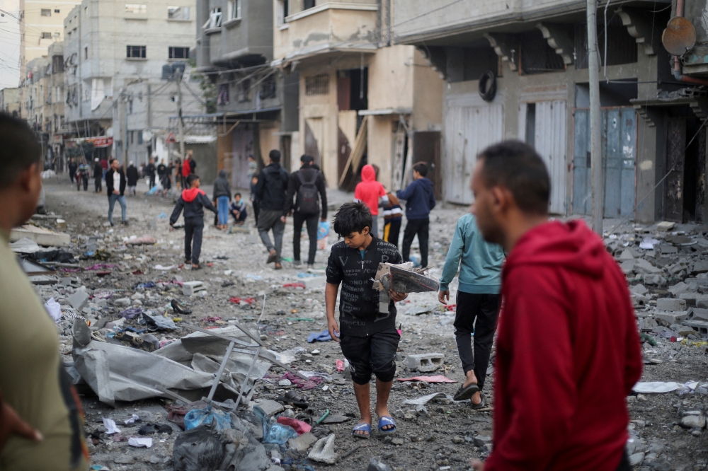 Palestinians inspect the site of Israeli strikes in Khan Younis 
