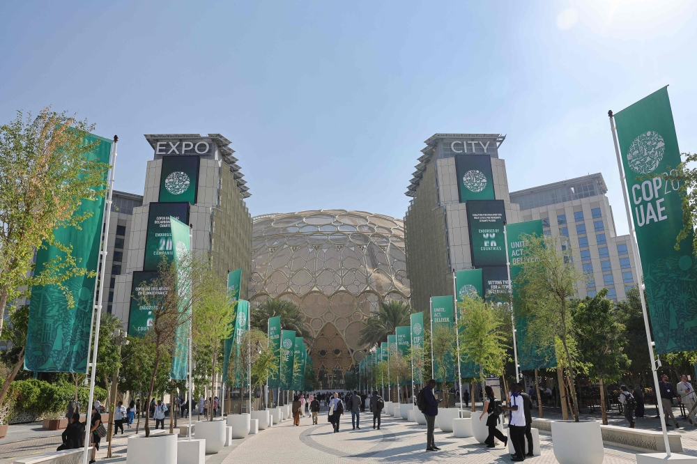 COP28- People walk at the venue of the COP28 United Nations climate summit in Dubai on December 6, 2023. A record almost 2,500 fossil fuel lobbyists have been accredited for UN climate talks in Dubai. _AFP