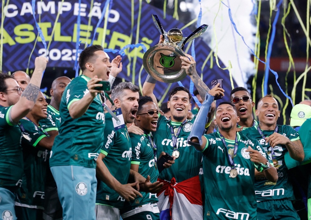 Soccer Football -  Brasileiro Championship - Cruzeiro v Palmeiras - Estadio Mineirao, Belo Horizonte, Brazil - December 6, 2023 Palmeiras players celebrate winning the Brasileiro Championship with the trophy REUTERS/Cris Mattos
