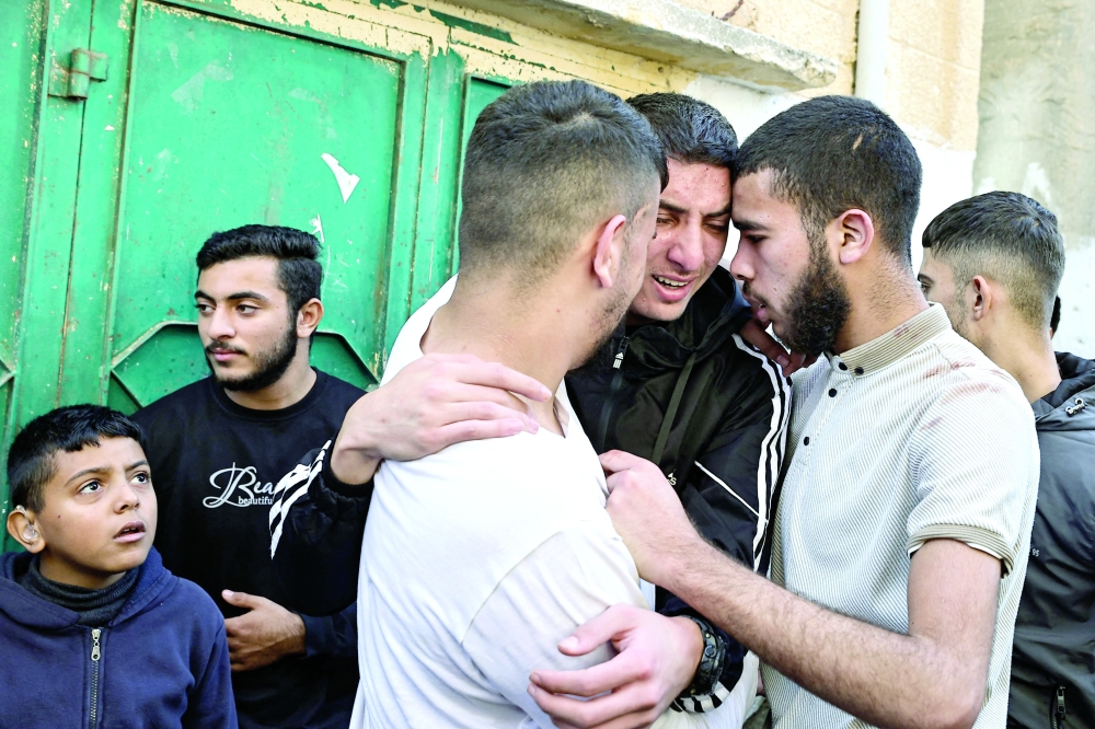 (Shared Grief) Relatives mourn a man killed during an Israeli raid in the occupied West Bank. — AFP 