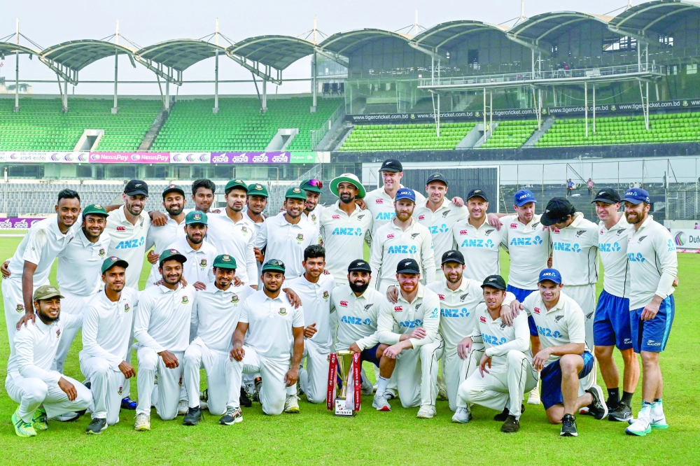 Bangladesh's and New Zealand's players pose with the trophy at the end of the second Test.— AFP


