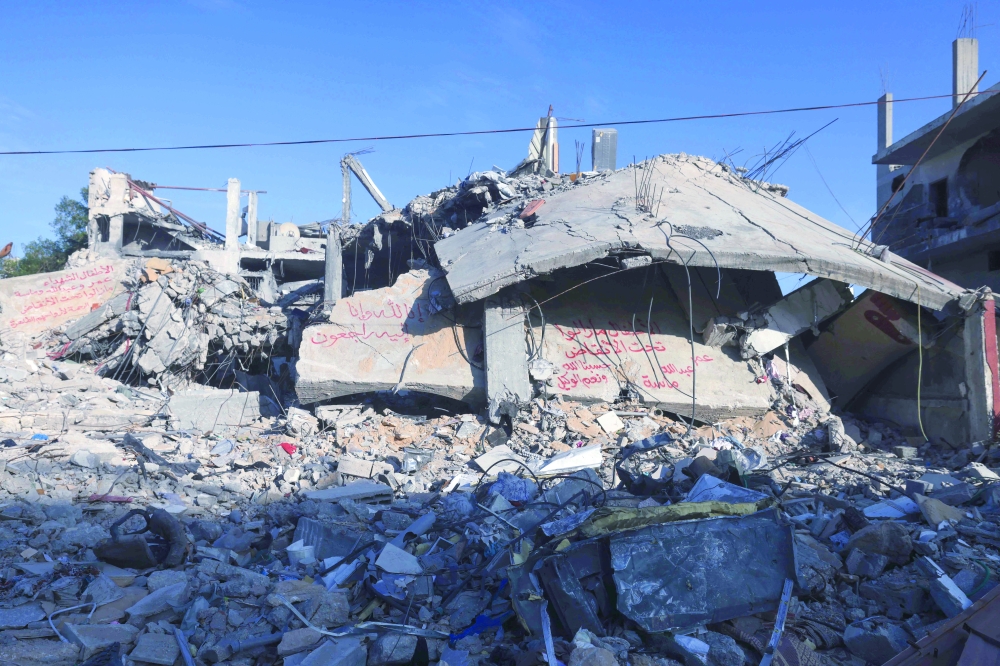An concrete slab from a destroyed building reads 'The children are still under the rubble, Omar, Abdullah, Masah,' in Rafah in the southern Gaza Strip. - AFP
