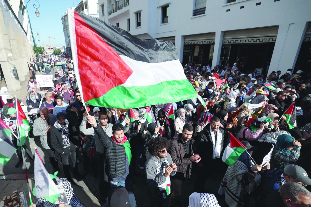 Moroccans wave Palestinian flags during a protest in Rabat in solidarity with the Palestinians amid Israel's relentless bombardment of the Gaza Strip. - AFP