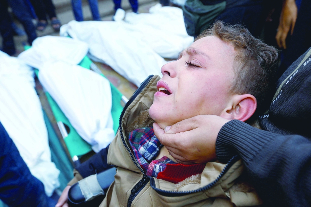 An injured Palestinian boy reacts as he attends the funeral of family members who were killed in the raid at Nasser hospital in Khan Younis, in the southern Gaza Strip. - Reuters

