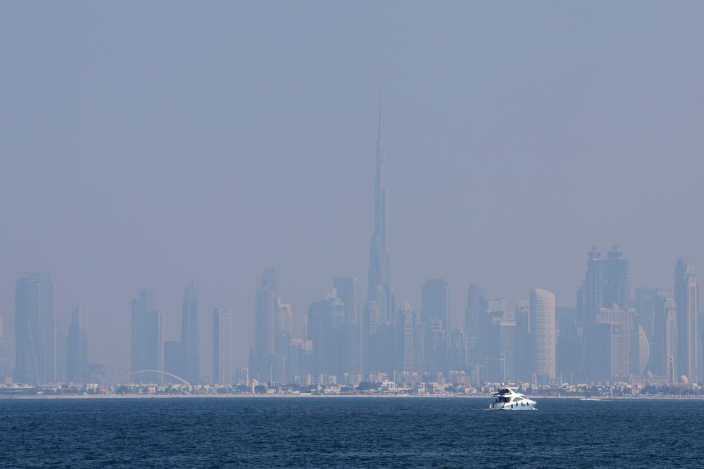 Dubai's skyline including Burj Khalifa, the world's tallest building, is overcast by haze on December 10