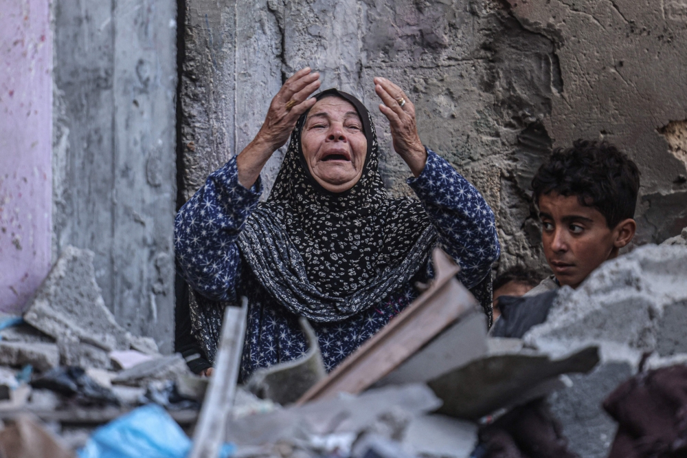 TOPSHOT - A Palestinian woman reacts following Israeli bombardment in Rafah, in the southern Gaza Strip on December 14, 2023, amid ongoing battles between Israel and the Palestinian militant group Hamas. Israeli leaders on December 13, they intend to press ahead with the Gaza Strip war against Hamas, despite coming under increasing international pressure, including from key ally the United States.
