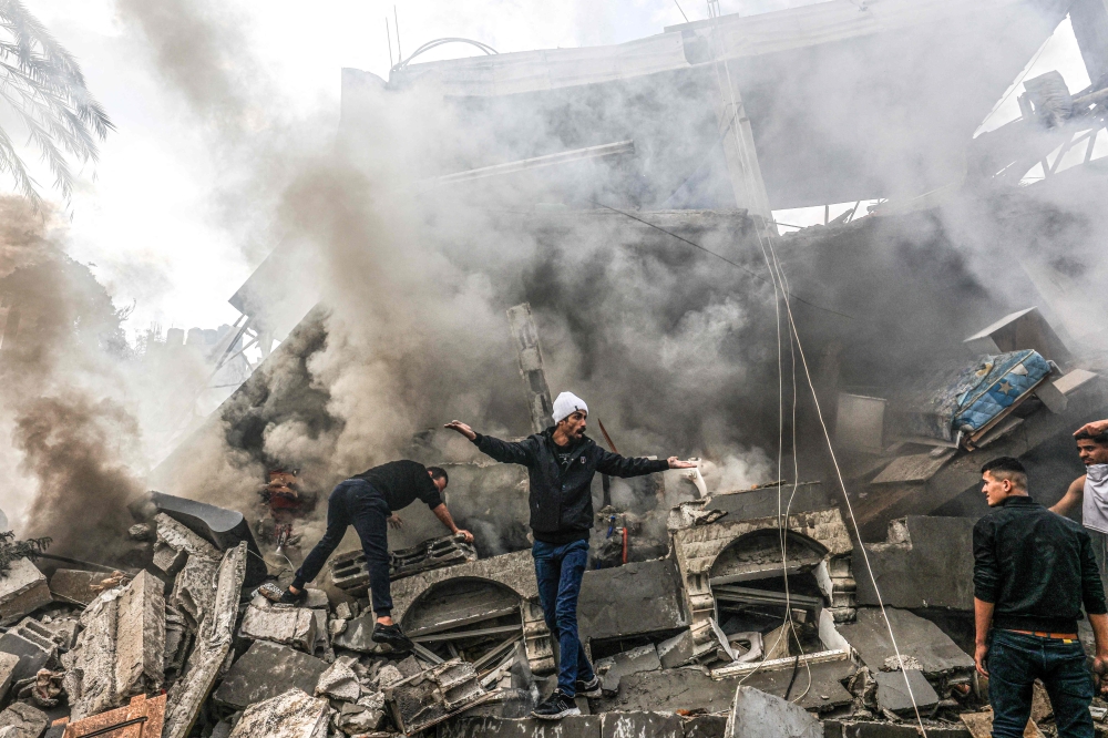  Palestinians react amid the rubble of destroyed buildings following an Israeli bombardment. — AFP 