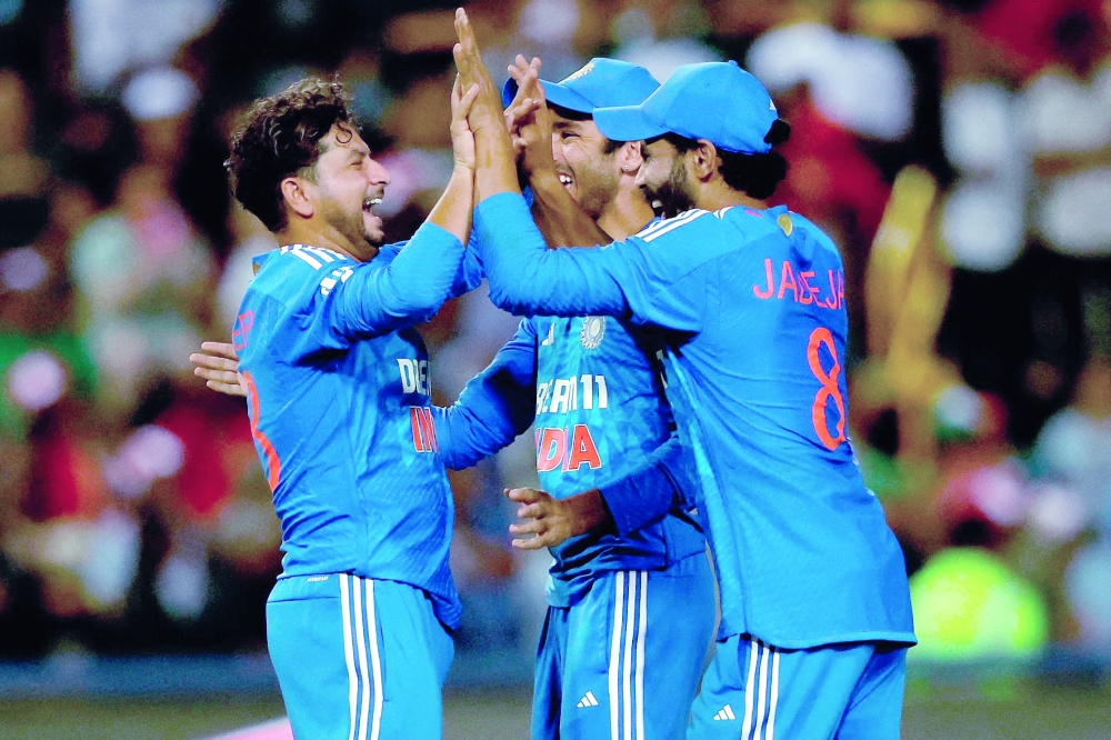India's Kuldeep Yadav (L) celebrates with team-mates after the dismissal of South Africa's Lizaad Williams (unseen) during the third T20 cricket match between South Africa and India at the Wanderers Stadium in Johannesburg on December 14, 2023. (Photo by PHILL MAGAKOE / AFP)