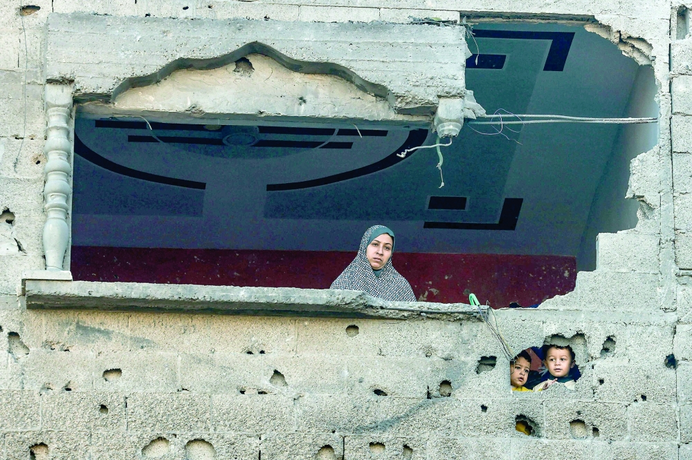 A Palestinian woman and children look on following Israeli bombardment on Rafah, in the southern Gaza Strip. — AFP