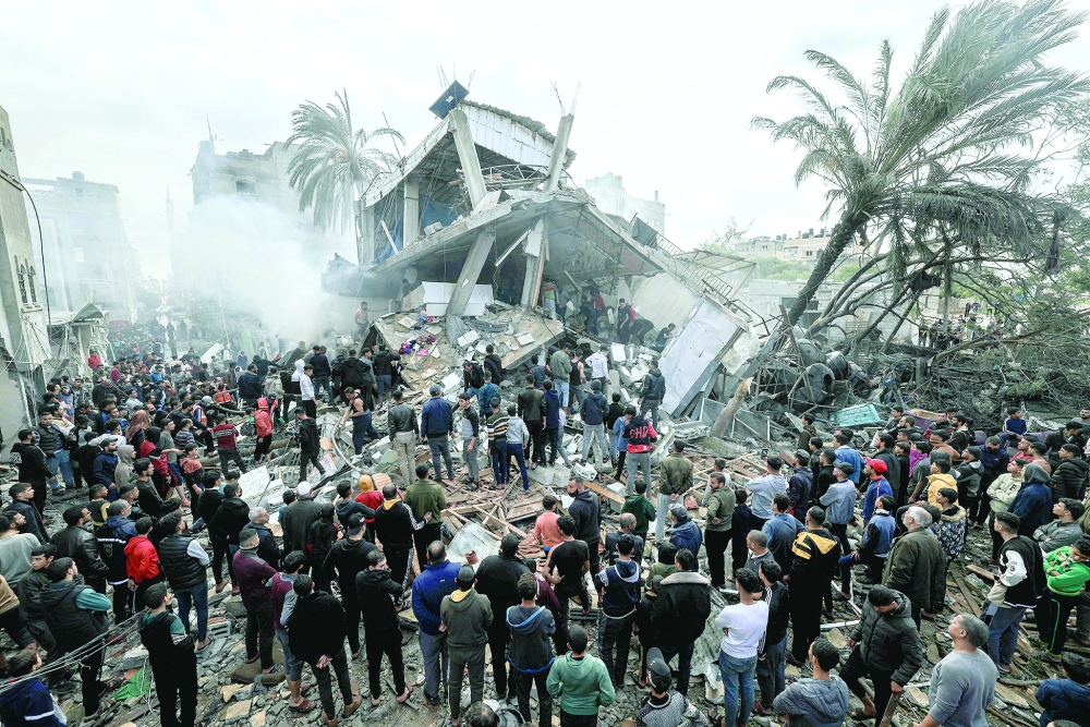 Palestinians gather around a destroyed house following Israeli bombardment of Rafah. — AFP 