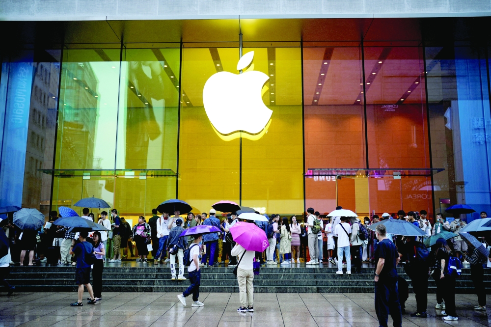 People stand outside an Apple Store in Shanghai, China. — Reuters
