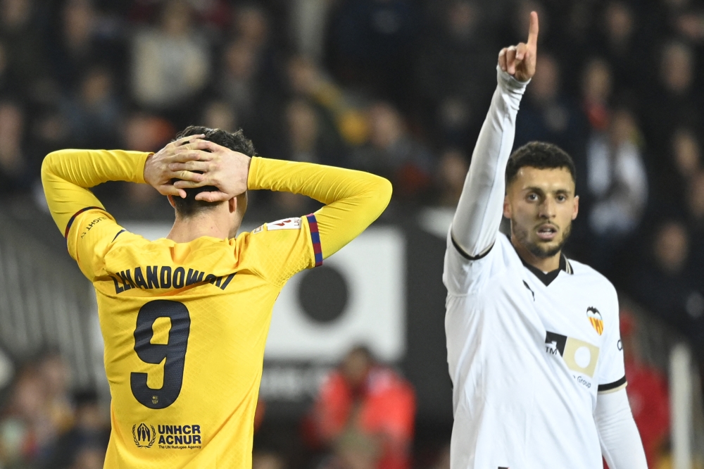 Barcelona's Polish forward #09 Robert Lewandowski reacts next to Valencia's Belgium midfielder #19 Selim Amallah.— AFP

