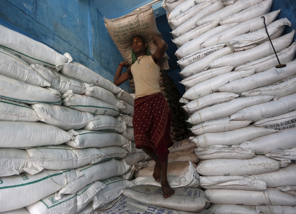 A labourer carries a sack filled with sugar in a store at a wholesale market in Kolkata. — Reuters
