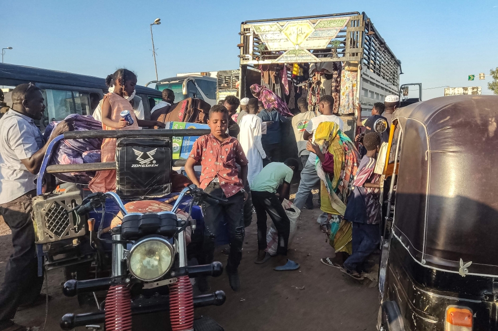 People displaced by the conflict in Sudan get in their transporation as they flee Wad Madani, the capital of al-Jazirah state, heading to Gadaref state on December 16, 2023. Fighting between the Sudanese army and paramilitaries engulfed the aid hub of Wad Madani on December 15, triggering an exodus of civilians already displaced by eight months of war, an AFP correspondent reported. (Photo by AFP)