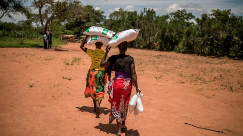 Women carry sacks in their head in Lusaka, Zambia. — AFP