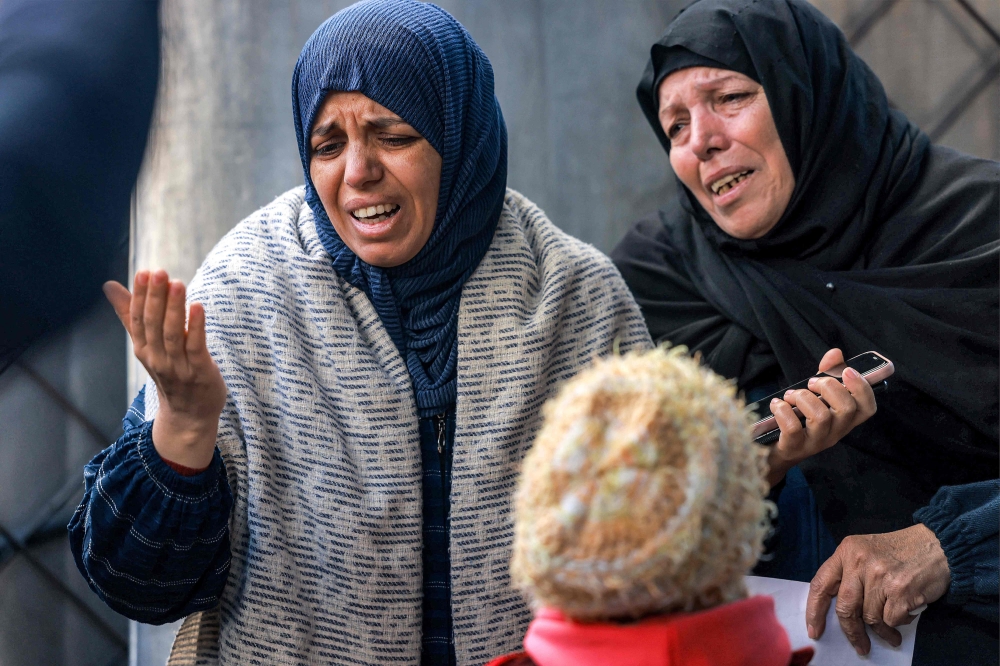 Women mourn the loss of loved ones who were killed overnight during Israeli bombardment, at a hospital in Rafah in the southern Gaza Strip. — AFP 