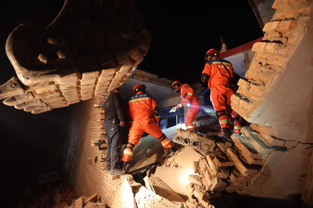 Rescue workers search a house for survivors after an earthquake in Kangdiao village, Dahejia, Jishishan County, on Tuesday. - AFP