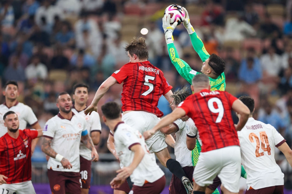 Manchester City's Brazilian goalkeeper #31 Ederson stops the ball over Urawa Reds' Norwegian defender #05 Marius Hoibraten during the Fifa Club World Cup football semifinal match between England's Manchester City and Japan's Urawa Red Diamonds at King Abdullah Sports City in Jeddah on December 19, 2023. (Photo by AFP)