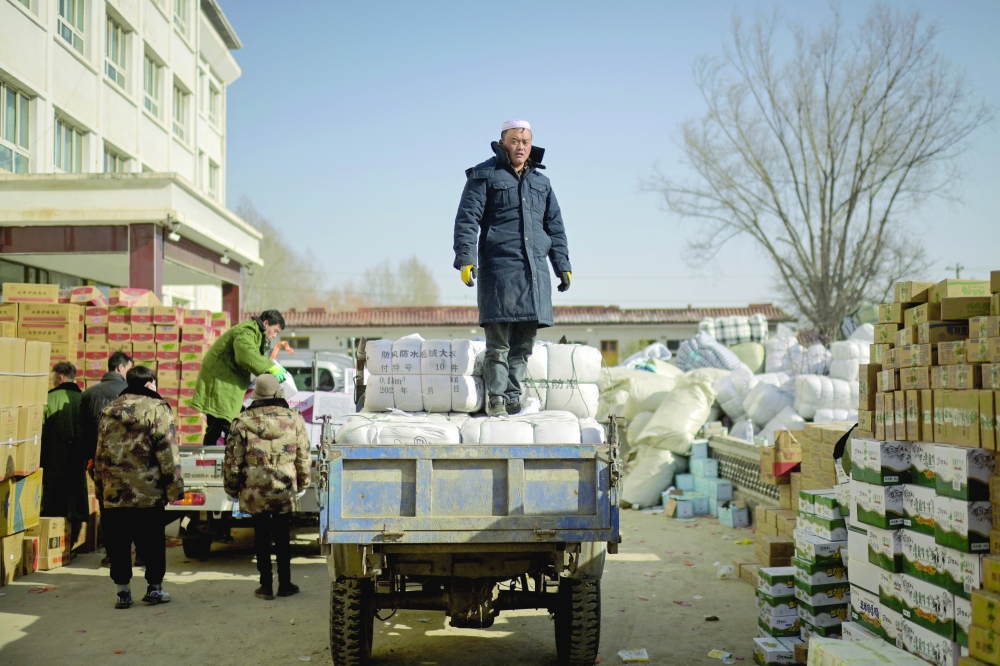 People work at an aid distribution centre for earthquake victims in Liugou Township in Jishishan County in northwest China's Gansu province. - AFP
