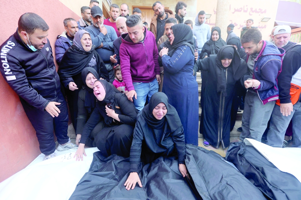 People mourn over the bodies of relatives, killed in Israeli bombardment, at Nasser hospital in Khan Yunis in the southern Gaza Strip. - AFP