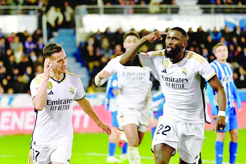 TOPSHOT - Real Madrid's Spanish forward #17 Lucas Vazquez celebrates with Real Madrid's German defender #22 Antonio Rudiger after scoring his team's first goal during the Spanish league football match between Deportivo Alaves and Real Madrid CF at the Mendizorroza stadium in Vitoria on December 21, 2023. (Photo by ANDER GILLENEA / AFP)