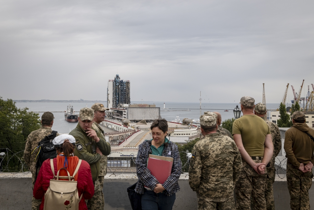 Ukrainian soldiers with a tour guide in the port area of Odesa, which has been struck by drones and missiles. 
