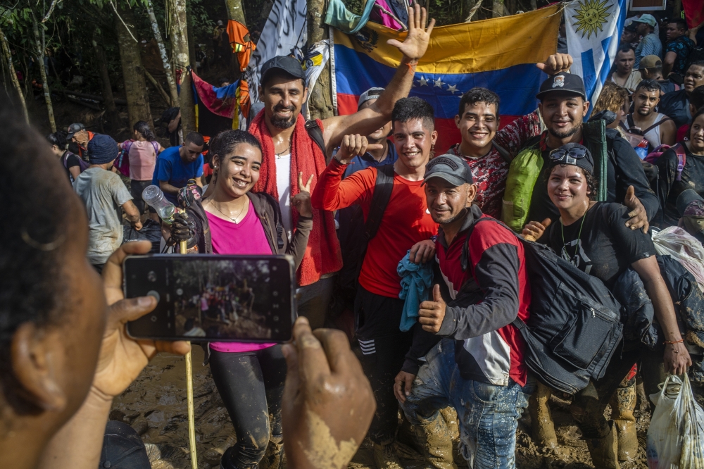 Migrants take a photo while crossing the Darien Gap, between Colombia and Panama, Sept. 27, 2022. - The New York Times