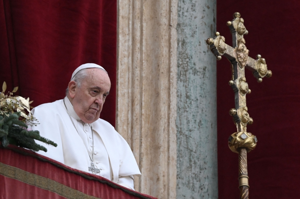 Pope Francis stands at the balcony of St. Peter's basilica to deliver the Christmas Urbi et Orbi blessing in St. Peter's Square at The Vatican. — AFP 